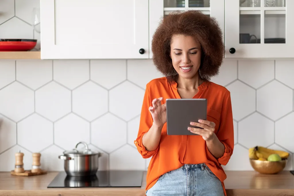 Une femme utilise son application DMI - Domuneo Mylight Inside afin de piloter l'autoconsommation optimisée de ses équipements électriques